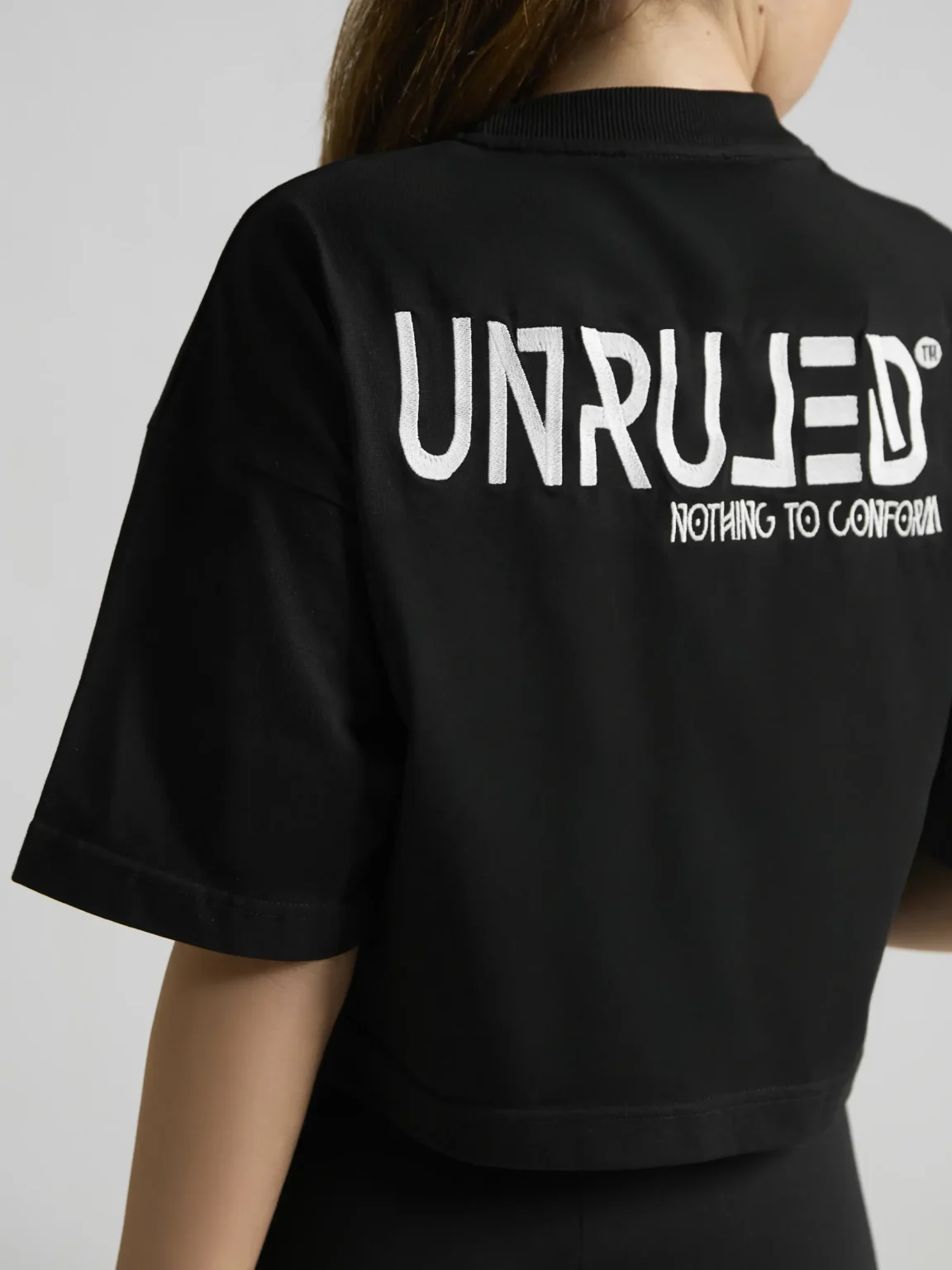 Black cropped T-shirt featuring a minimalist contemporary design by UNRULED.