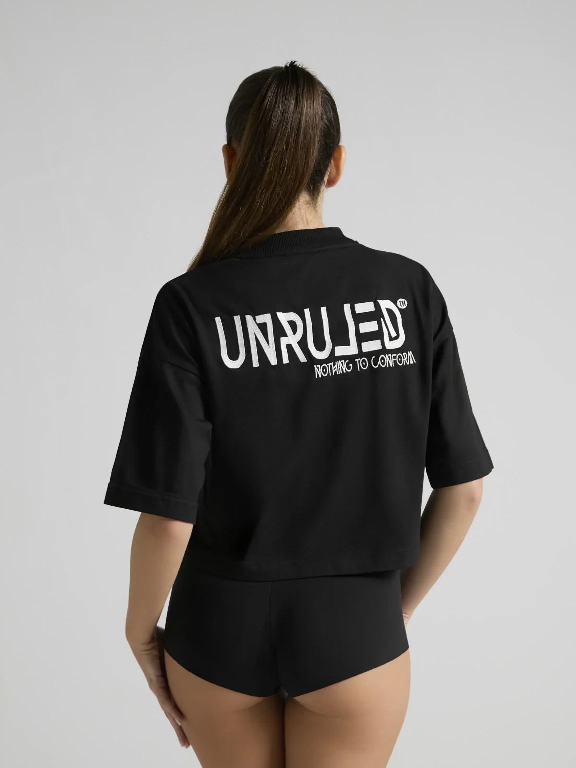 Minimalist women's streetwear styling with the UNRULED black crop top.