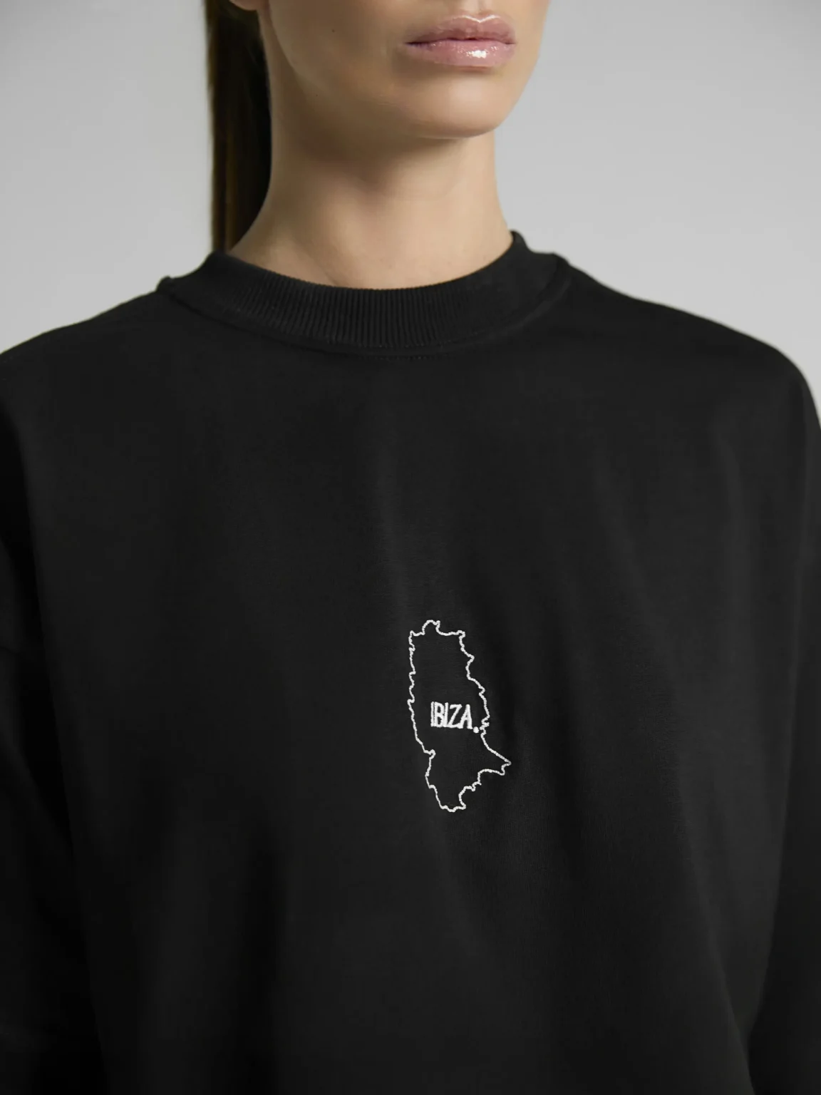 Women's black crop top with mesh inserts on shoulders and sides by UNRULED IBIZA collection.