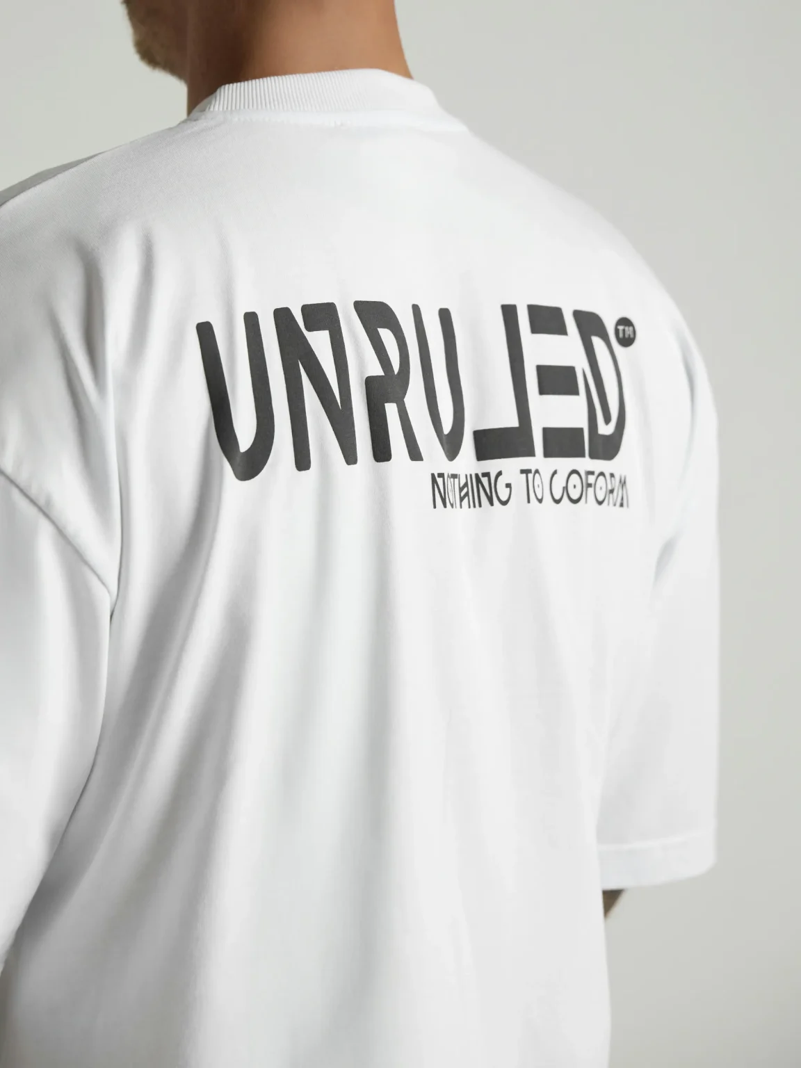 UNRULED white oversized T-shirt featuring a minimalist contemporary design.