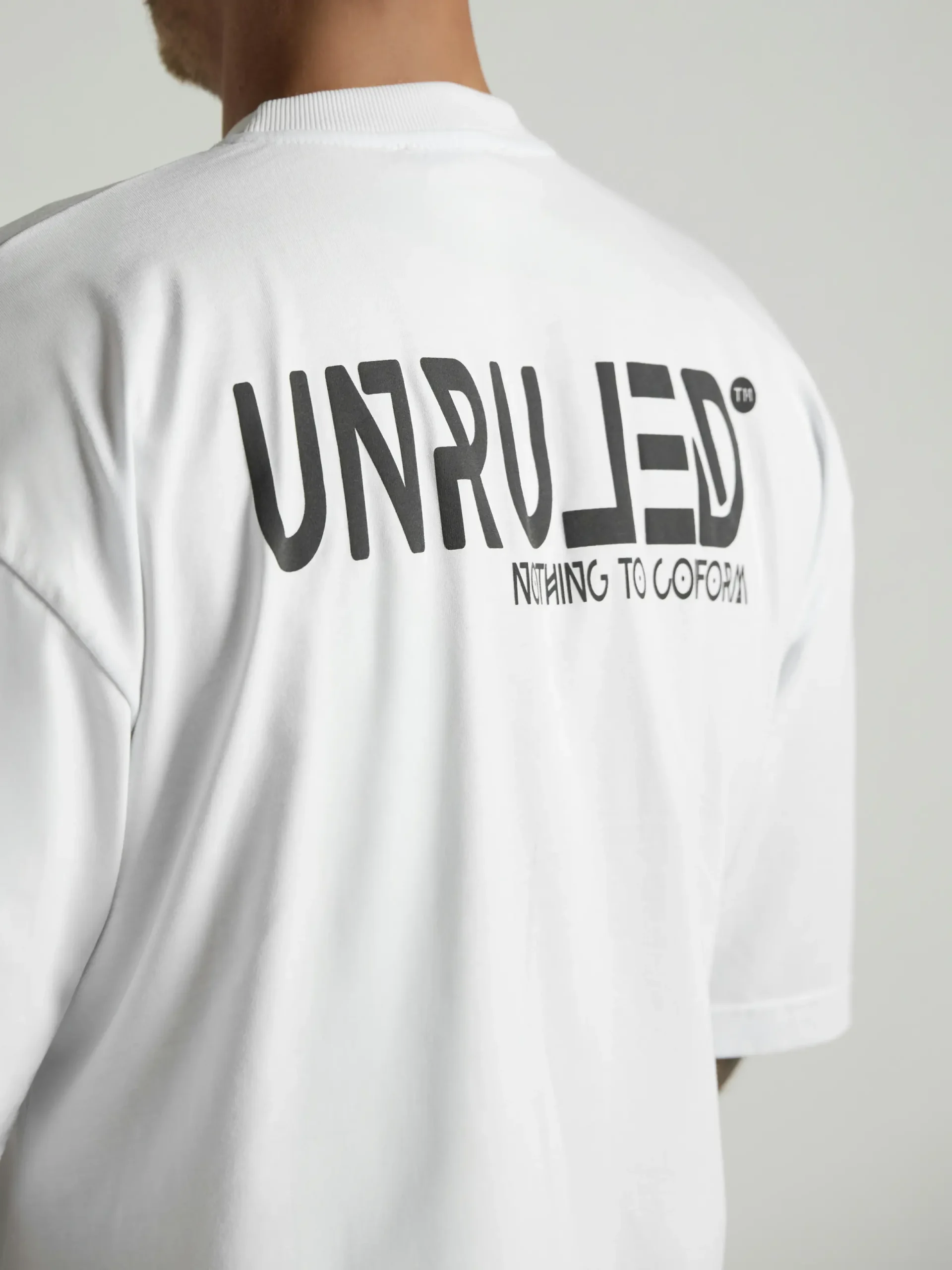 UNRULED white oversized T-shirt featuring a minimalist contemporary design.