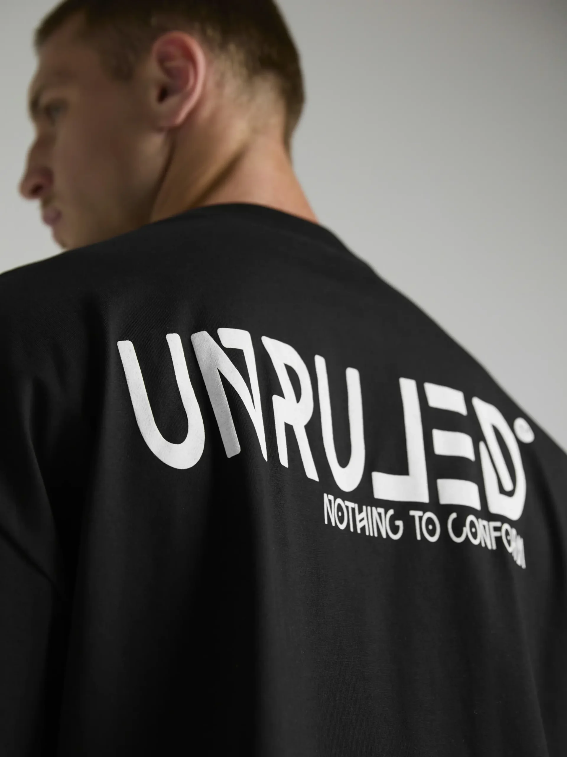 en's black oversized T-shirt from the UNRULED INSIDE Collection.